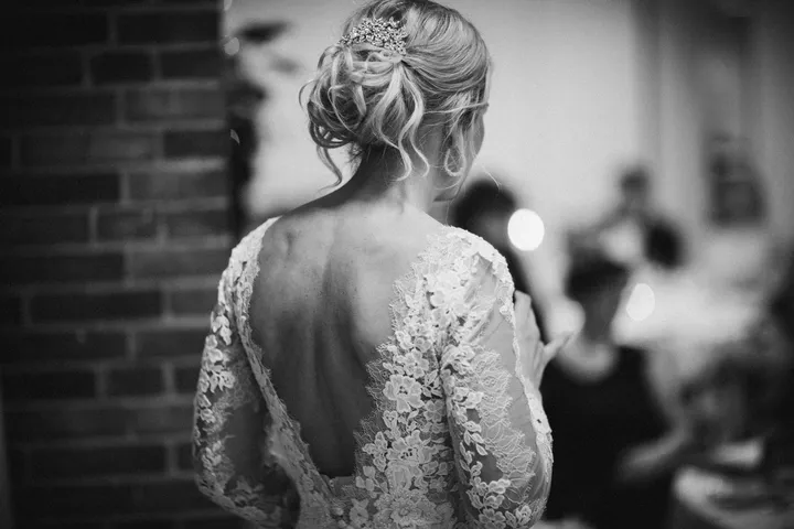 Dos d’une robe de mariée en dentelle, photographie en noir et blanc